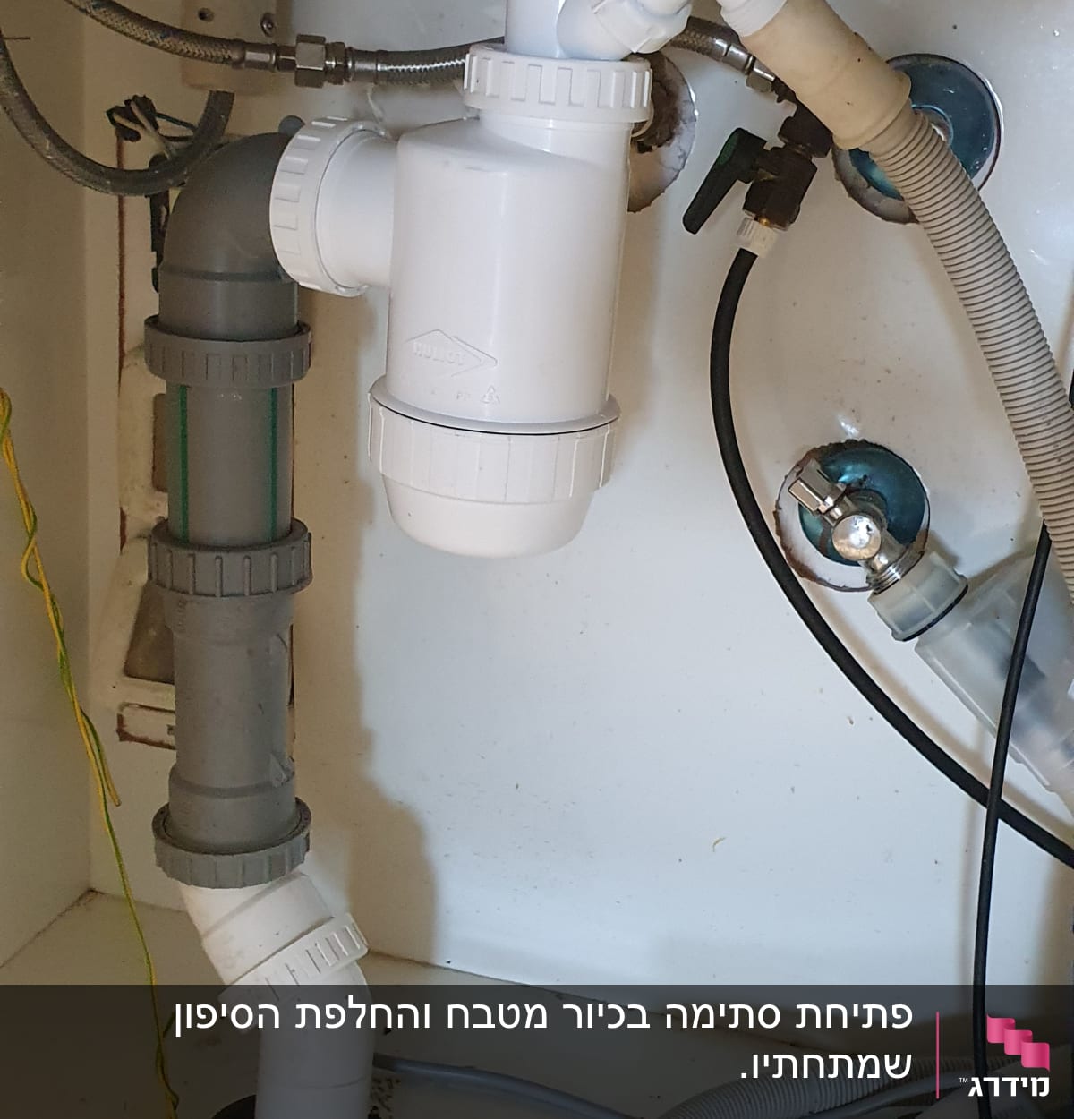 צנרת פלסטיק מתחת לכיור עם מחברים וברזים
